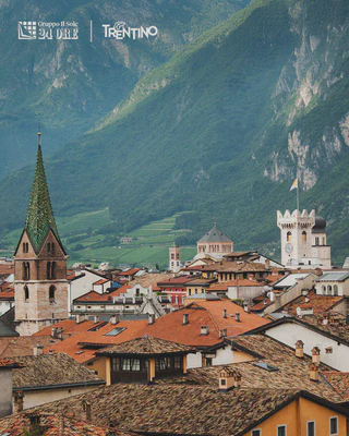 The rooftops and towers of Trento with the mountains behind